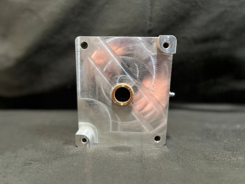 Metallic block with a central hole on a gray background