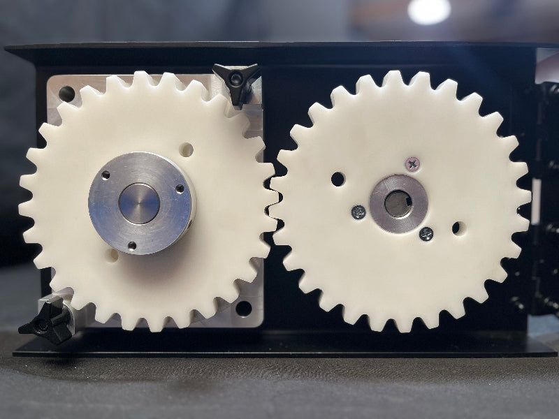 Two white gears with metal centers on a black background