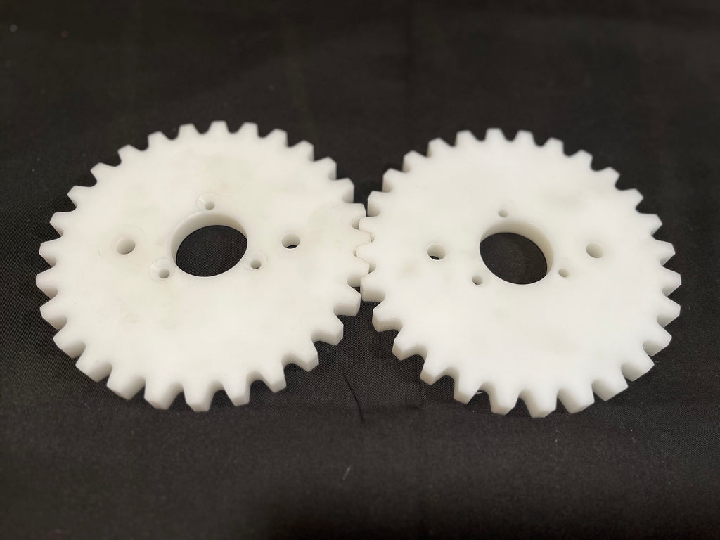 Two white plastic gears on a black background