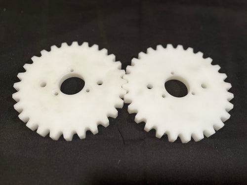 Two white plastic gears on a black background